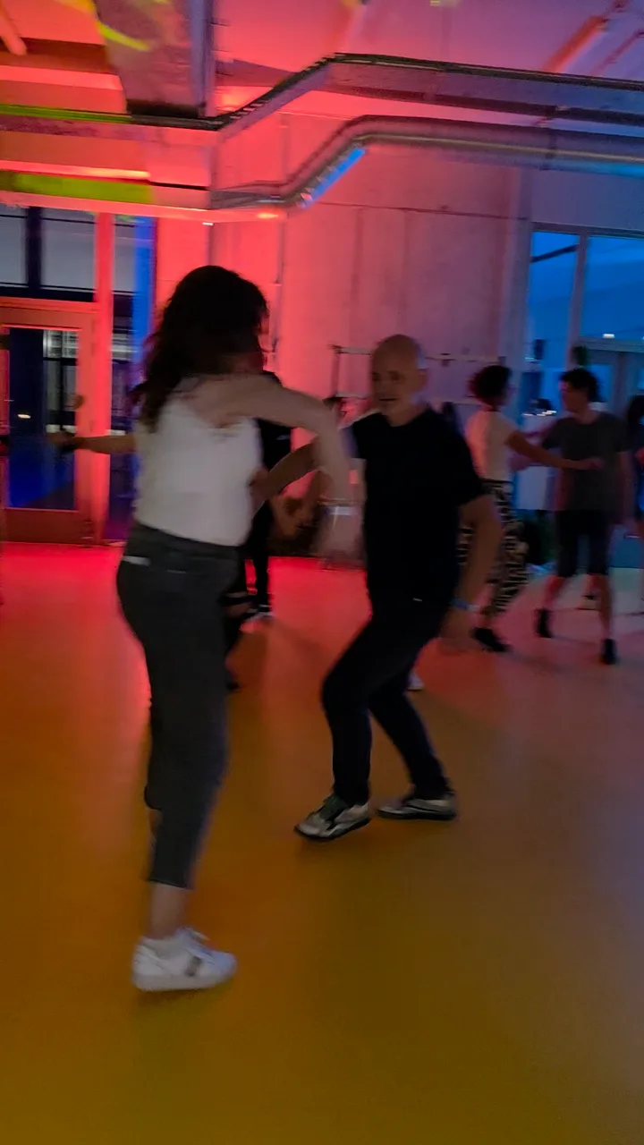 Couples dancing under red and blue lights