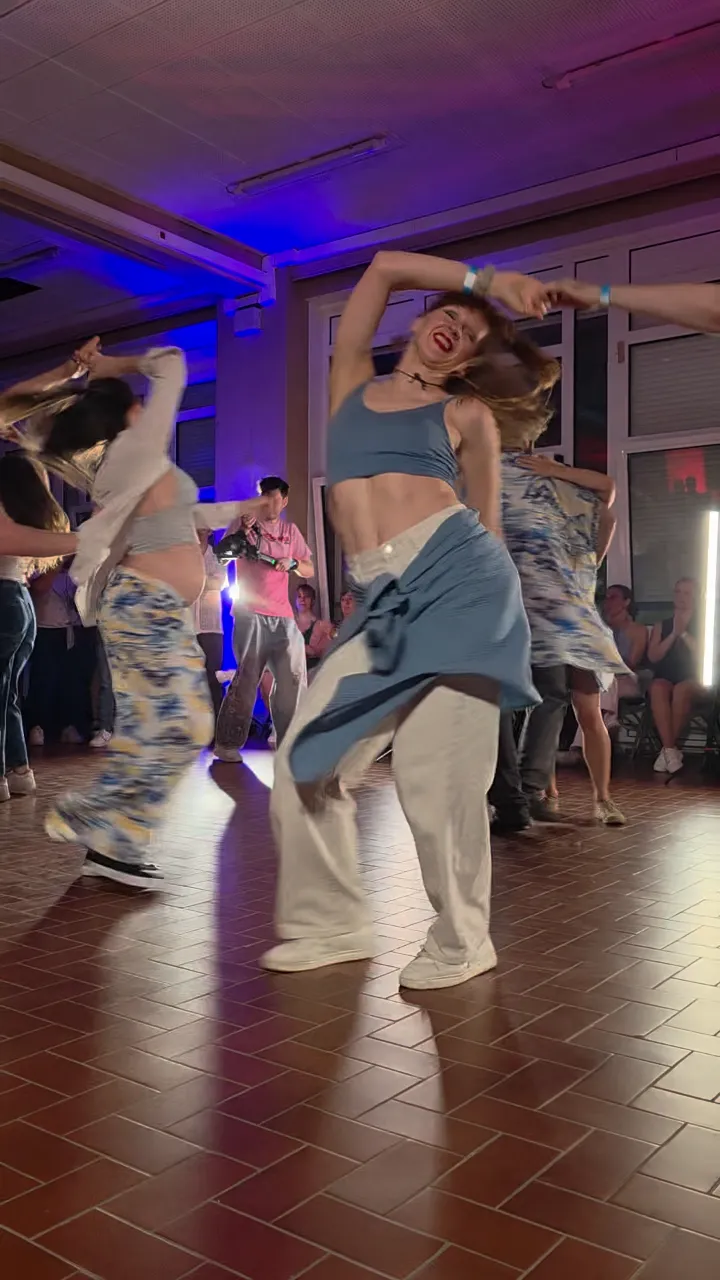 Dancers moving together on a lit dance floor